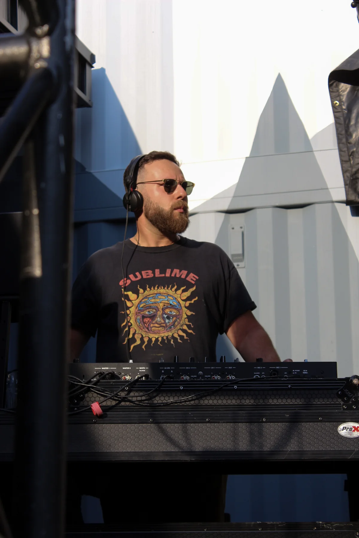 Kris Falco performing an outdoor festival set with headphones on